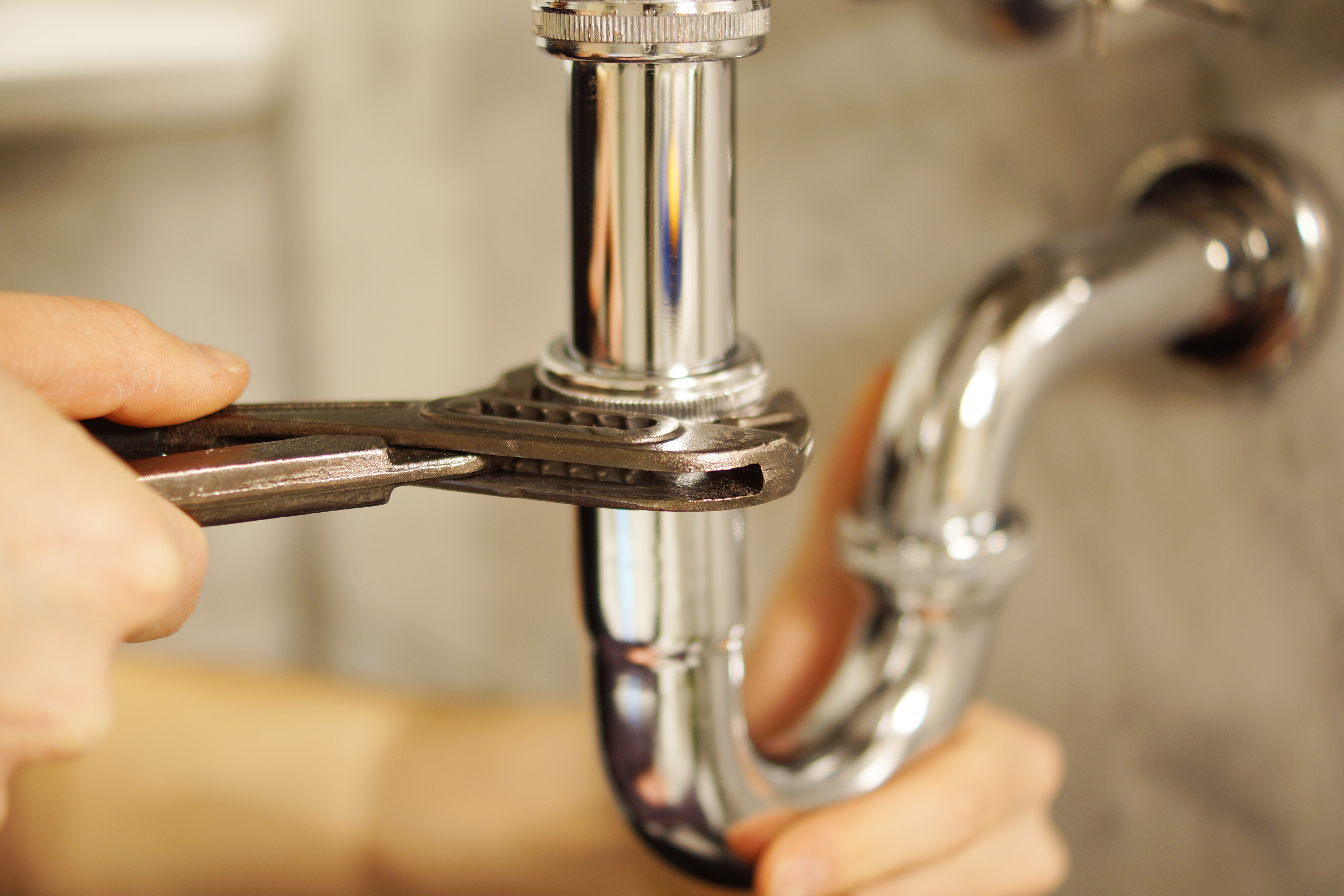 pipe wrench on pipe under sink